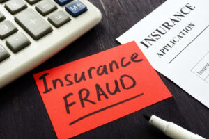 Insurance fraud sign and policy agreement on table. - insurance rating engine